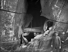 HMS HAWKE collision damage-middle hole looking forward, with two figures..jpg